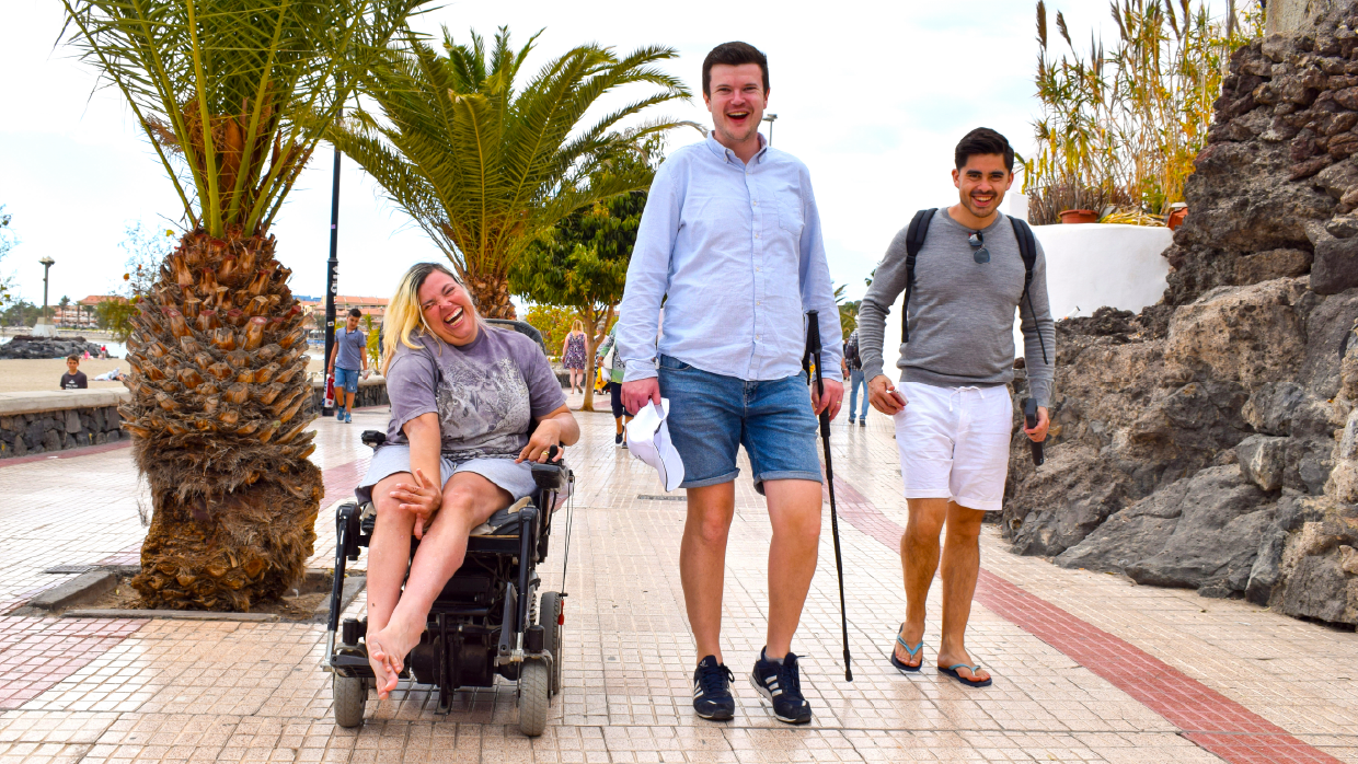 Three people side-by-side. One is in a wheelchair and another has a walking stick.png