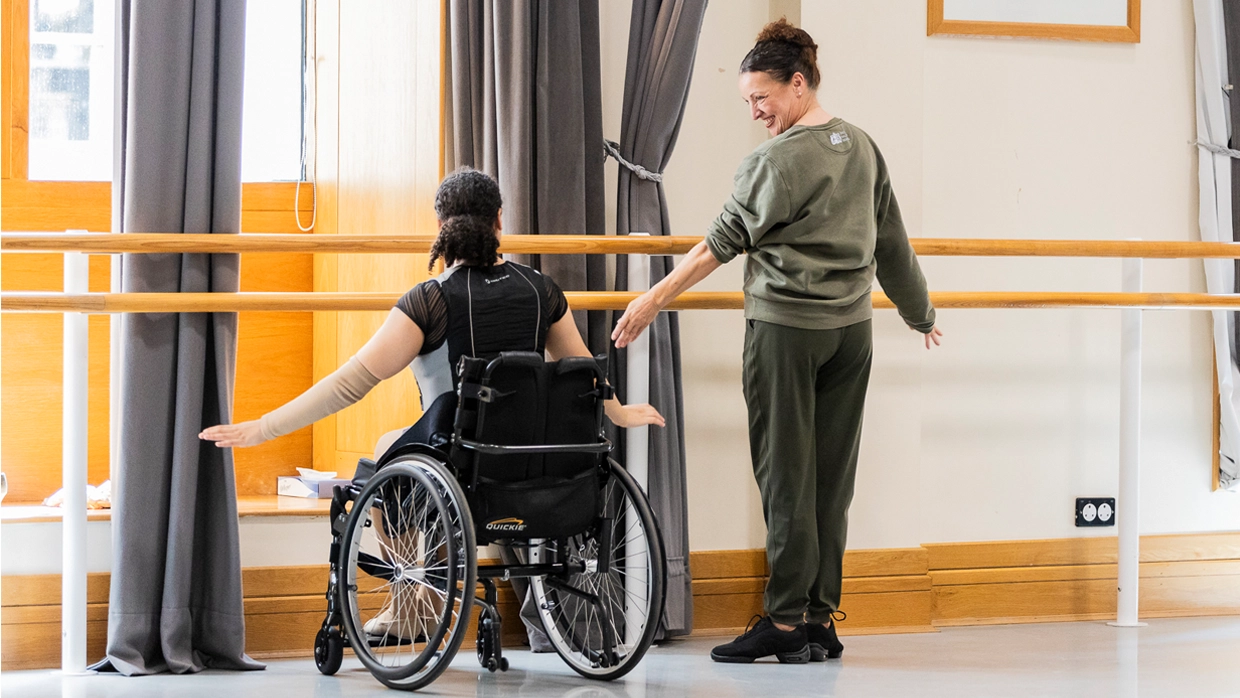 Photo of Rachael Hunt teaching ballet to a women in a wheelchair